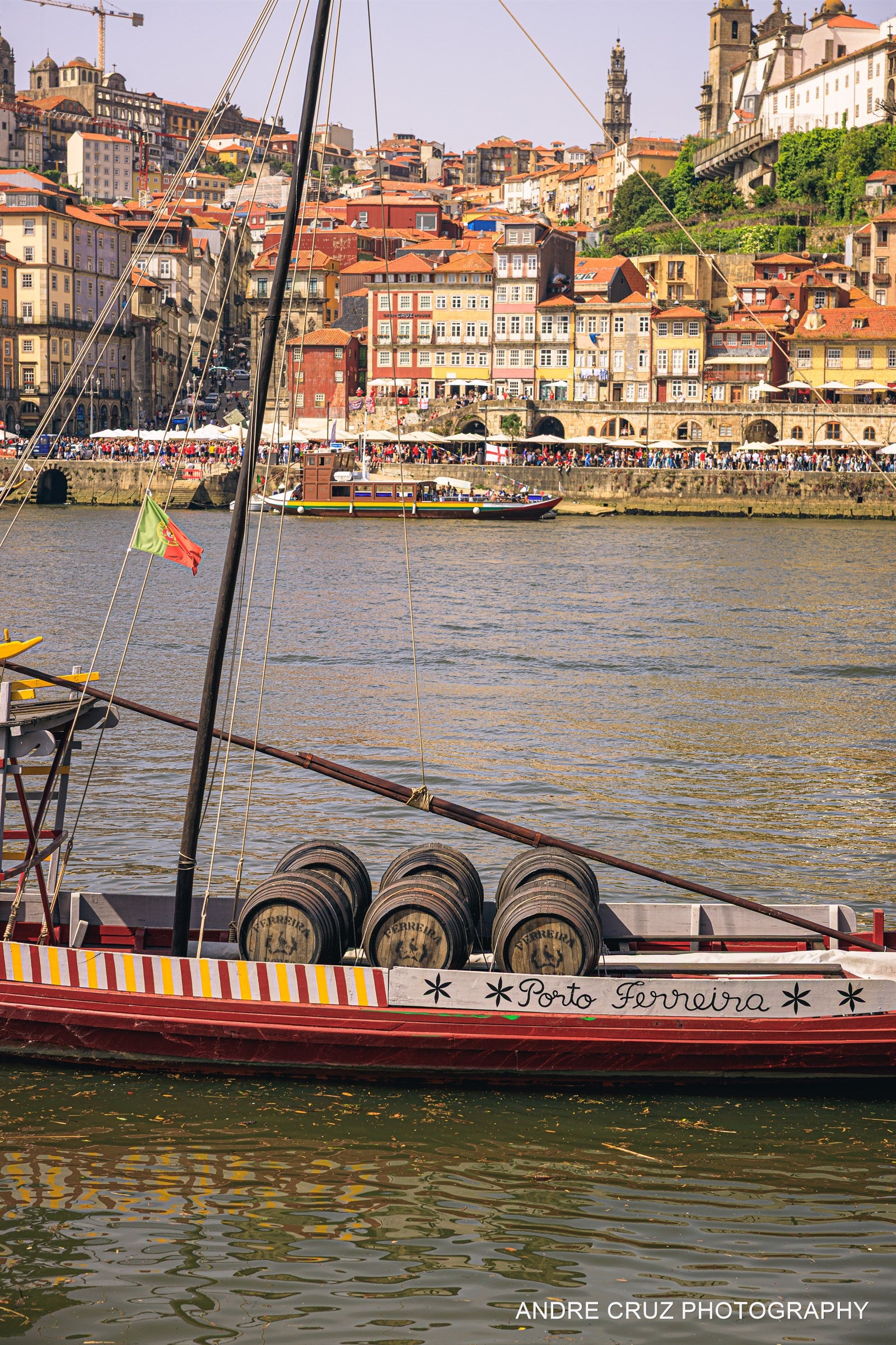 A traditional rabelo boat loaded with port barrels on the Douro river in front of the Ribeira, Porto